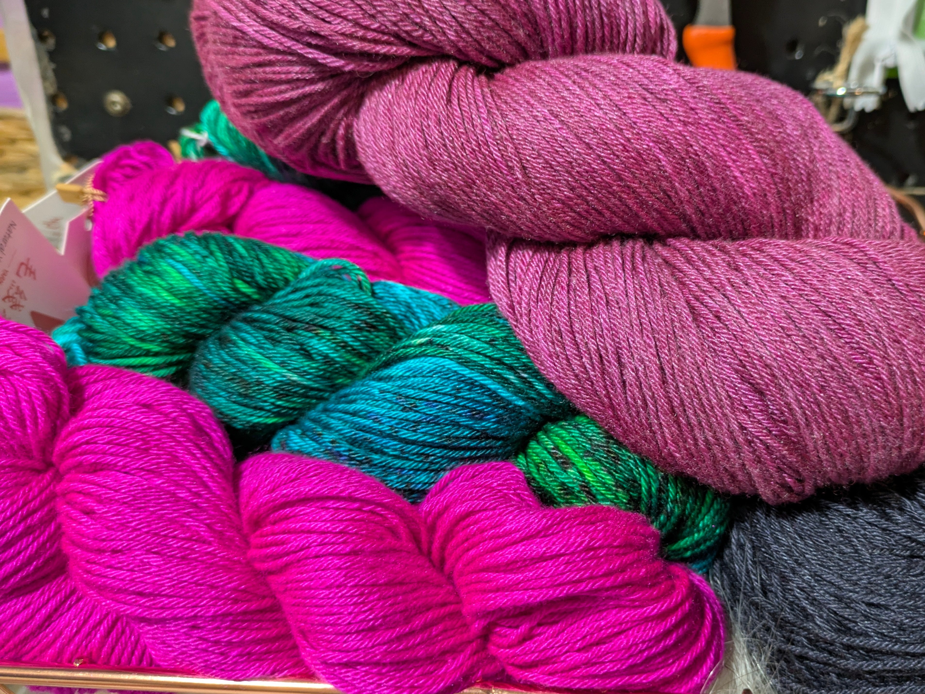 Balls of colorful yarn in various shades on a shelf.