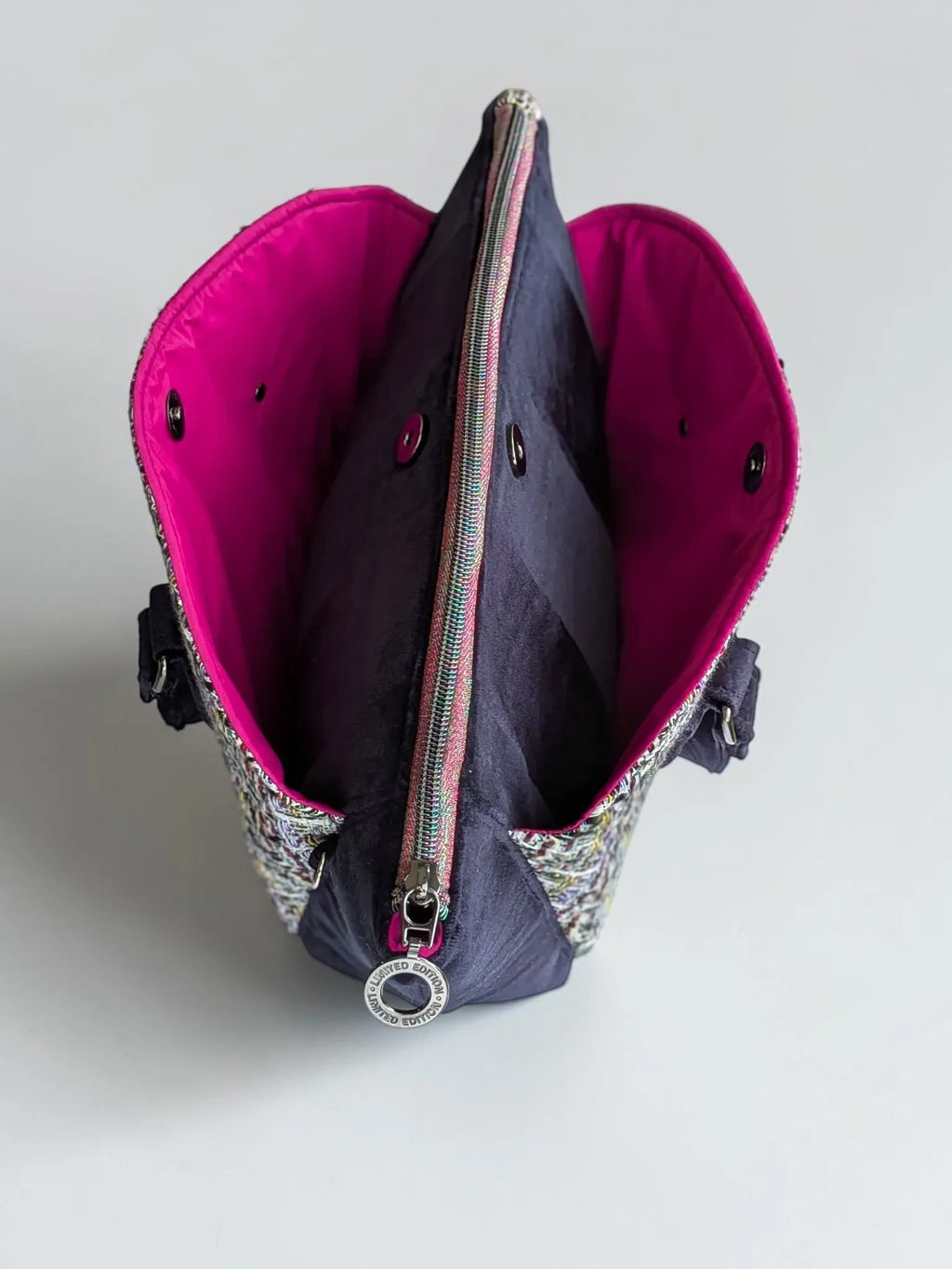 Fixation Fibre and Function structured handbag with multi-colored tweed, black velvet, and vibrant fuchsia interior.